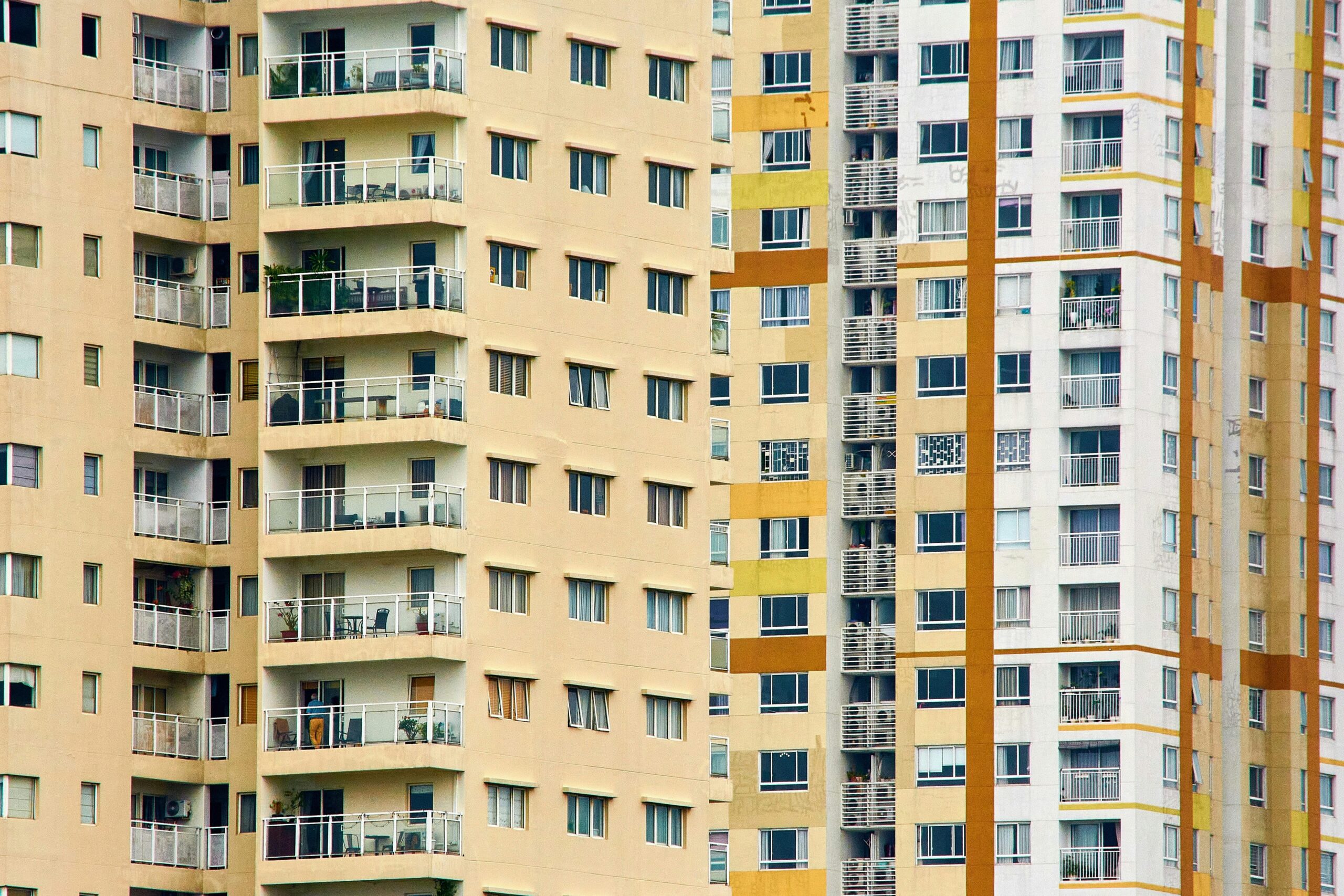 Close-up view of modern high-rise residential buildings with balconies and windows, emphasizing urban architecture.